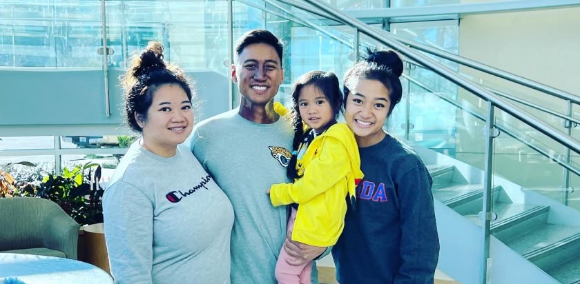 Patrick Palompo, his wife and daughters stand in the main lobby of the UF Health Proton Therapy Institute after he completed treatment for cancer of the head and neck.