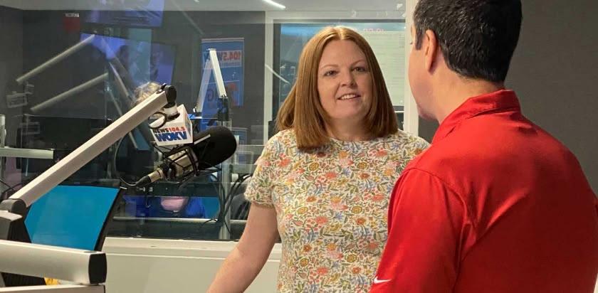 Kelly Jones stands in front of the microphone in the radio studio at WOKV with Rich Jones